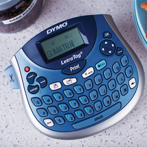Portable Handheld Label Maker With QWERTY Keyboard And 2 Line Printing shown on a countertop with printed label "Sumatra".