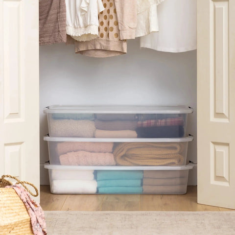 Heavy Duty 50 Quart Stackable Plastic Storage Bins With Snap Tight Secure Lids Clear Organizers For Home Office Dorm Room Garage No Sweat Bulk Pack Of Three with folded clothes in a closet.