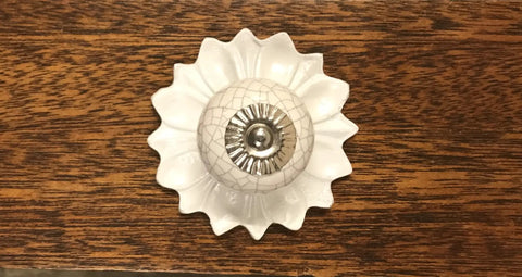 Heavy Duty White Decorative Metal Back Plate For Cabinets And Drawers with a floral design and shiny center on a wooden surface.