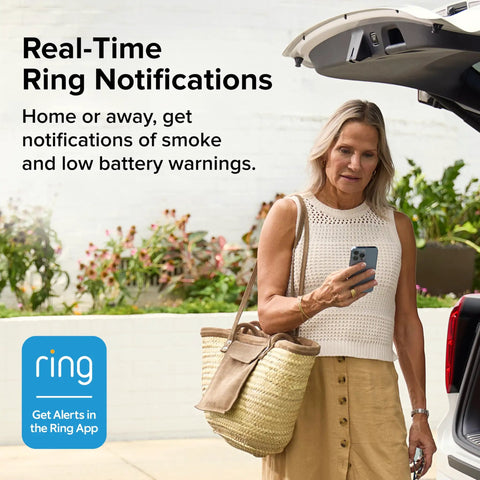 Woman checking phone for real-time alerts from Kick Butt Protection Smart Smoke Detector Hardwired With Battery Backup Ring App Integration.