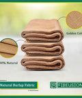 Stack of natural burlap fabric rolls, 40 in x 15 ft, showing golden color and texture, labeled '100% Natural' and 'Golden Color'.