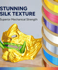 Top Shelf Silk PLA Filament 1.75mm 3D Printer Spool with golden mask and colorful spools, ideal for cosplay and art.