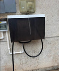Heavy Duty Outdoor Ev Charger Rain Cover Featuring Galvanized Steel Construction And Wall Mount Spacing For Nasty Weather And Hella Tough Type Two Housing on wall with water droplets.