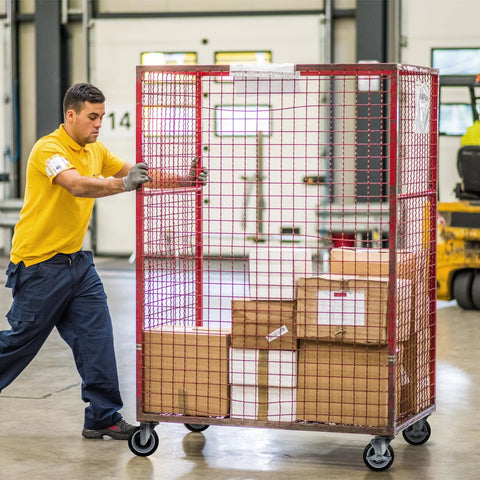 Warehouse worker pushing a large red wire cage cart on heavy duty 5 inch swivel caster wheels set of 4 with 1400 lb load capacity.
