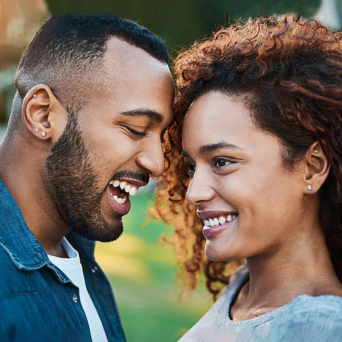 Couple smiling while wearing Snag These Fresh Flat Back Earrings Made From Light As Air Titanium Surgical Steel With Diamond Like Cubic Zirconia.