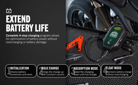 12V Smart Battery Charger And Maintainer For Powersports Riders Straight Up Restoration Of Motorcycles ATVs And UTV Batteries on black mat with alligator clips.
