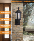 Dusk To Dawn Sensor Outdoor Wall Lantern With Built In GFCI Outlet on stone wall, showcasing durability and weatherproof features.