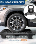 Car parked on 4 Pack Plastic Pallet With Perforated Ventilated Grid, Modular Stackable Tray, Beefy 2200 Lb Capacity Forkliftable For Garage And Workshop, Easy To Clean