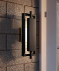 16 Inch Slick Matte Black Outdoor Wall Lantern With Integrated LED features a geometric design on a textured wall.