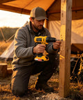 User operating Heavy Hitter Cordless Power Drill And High Torque Workhorse for woodworking tasks near a tent.