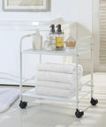 Sturdy White Two Tier Metal Rolling Utility Cart With Smooth Swivel Casters And Reinforced Steel Trays For Tight Quarters And Busy Desks, holding towels and toiletries.