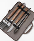 Stainless Steel BBQ Grill Tools Set With Ergonomic Wood Handles Includes Spatula Tongs Knife Fork And Carry Bag displayed neatly