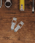 Nickel Plated Spring Loaded Duckbill Toggle Latches Set with tape measure on wooden surface