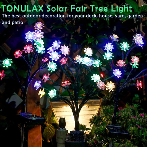 Colorful illuminated solar tree lights in a garden setting at night