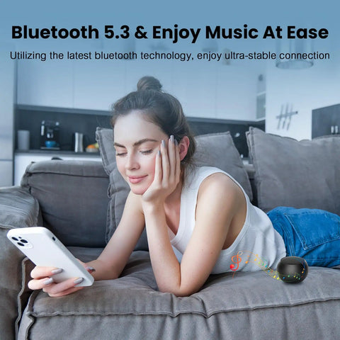 Woman using a smartphone on a couch next to Pocket Bluetooth Speaker With Big Bass, 5W Portable Wireless Speaker, IPX7 Waterproof, 8 Hours Playtime.
