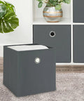 Foldable Gray Storage Cube With Sturdy Metal Ring Handle, No Sweat Shelf Bin Great For Bedroom Or Living Room, Quick Wipe Clean Fabric Organizer To Snap Shut And Hold Your Daily Gear on a carpet, featuring a gray design.