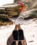 HeroClip Medium Carabiner Gear Clip And Hook For Camping Backpack And Garage Organization in use on a log, holding shoes