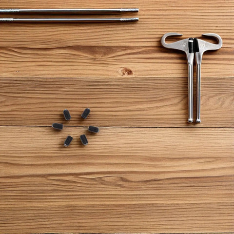 Rock Solid M4x6 Stainless Steel Ball Point Spring Plunger Set Screws 50 Pieces arranged on wood, with tools for industrial assembly.