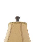 Close-up of beige silk bell shade with trim on an Antique Style Polystone Buffet Table Lamp With Tassel Pull Chain In Bronze Finish