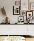 Modern living room with white cabinet showcasing framed art and decorative items on a dark countertop.