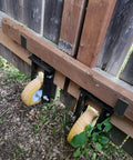 Heavy Duty 2x4 Door Barricade Brackets With Quick Drop Bar And Pin Hook For Tough Shed Barn Gate Latch Black Powder Coated Steel Security Setup Includes Four Badass Rock Solid Plates with mounted yellow wheels.