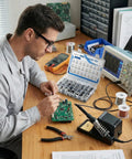 Man using No Brainer 400Pcs SMD Aluminum Electrolytic Capacitor Kit to repair a circuit board on a workbench.