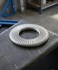 M6 40 Pack Premium 304 Stainless Steel Conical Spring Washers With Single Side Knurl Grip placed on a workbench.