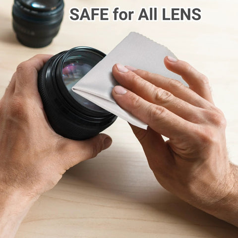 Close-up of hands wiping a lens with a light gray microfiber glasses cleaning cloth
