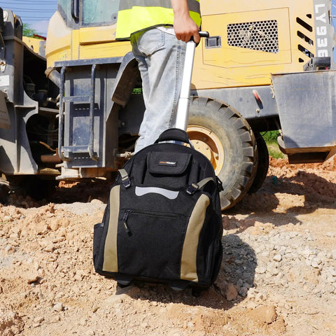 Person transporting Rugged Rolling Tool Backpack With Wheels 26 Pocket Organizer For Electricians Carpenters HVAC And Welders Built To Last In Durable 600D Polyester Worksite Ready On The Go on a construction site