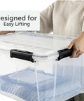 Close-up of a person lifting a Massive 80 Quart Clear Plastic Storage Bin With Hella Tight Waterproof Seal and Heavy Duty Latches.