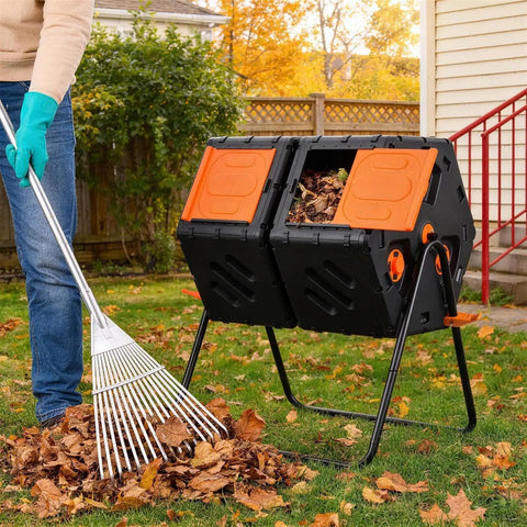 Person raking leaves next to Double Chamber Rotating Compost Tumbler 170L Outdoor Bin With Elevated Base, Hands Free, in garden setting.