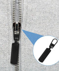 Close-up of 8 Pack Black Zipper Pull Replacements For Jackets And Coats Bags And Luggage Easy Install Zipper Sliders on gray fabric
