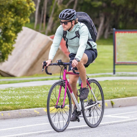 Cyclist on a pink road bike in a park setting