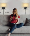 Woman using phone under Bedside Wall Lamp Set Of 2 Plug In Sconce Lights With USB Charging Ports And AC Outlet Brushed Nickel