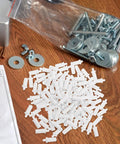 White Shutter Repair Pins, 120 Piece Movable Louver Fasteners scattered on a wooden surface with various hardware supplies.