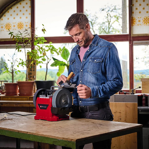 Man using Built Tough Electric Wet Bench Grinder With High Speed Grinding Stone And Leather Honing Wheel for knife sharpening.