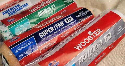 Various brands of paint roller covers including Wooster, shown in packaging, for painting walls and ceilings with smooth finishes.