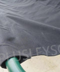 Close-up of black Beefed Up 900D Porch Swing Replacement Fabric for all weather protection, draped over green frame.