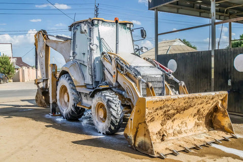 Construction backhoe loader being cleaned with Touchless Heavy Equipment Cleaner One Step Detergent Soap Concentrate Foam