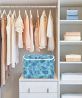 Sturdy Collapsible Storage Bin With Flip Top Lid And Easy Grip Handles For Bedroom Organization 300d Oxford Fabric Foldable Closet Box With Secure Velcro Closure in a closet with hanging dresses.