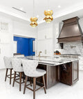 Modern kitchen with white cabinets, marble island, and decorative pendant lights.