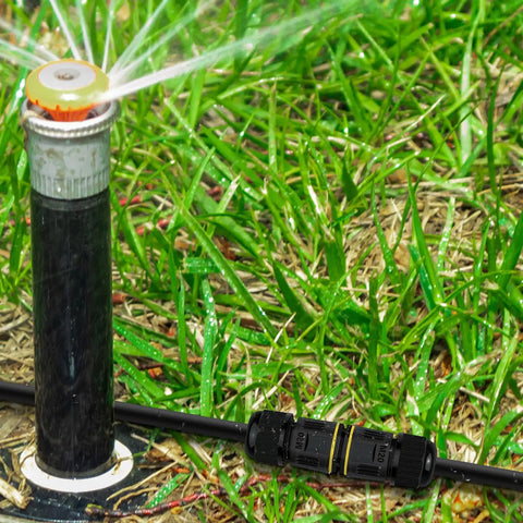 180 Pack Outdoor IP68 Waterproof Junction Box With 3 Pin Wire Connectors near a garden sprinkler on grass.