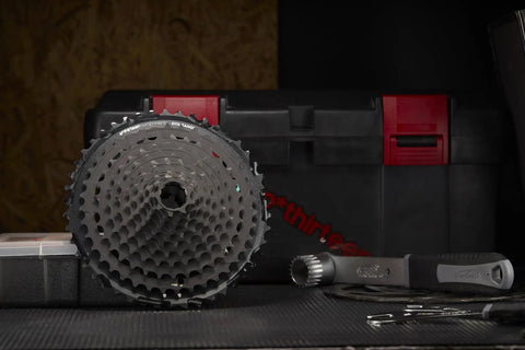 TRS Plus 11-Speed Mountain Bike Cassette 9-46T Black displayed on a workbench, showing its durable and lightweight design.