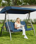 Woman sitting on Upgraded 3 Seat Porch Swing With Canopy And Stand For Backyard Patio, 180 Degree Recline, 3 In 1 Heavy Duty Swing With Waterproof Cushions And Cup Holders, Blue Square Tube in a garden