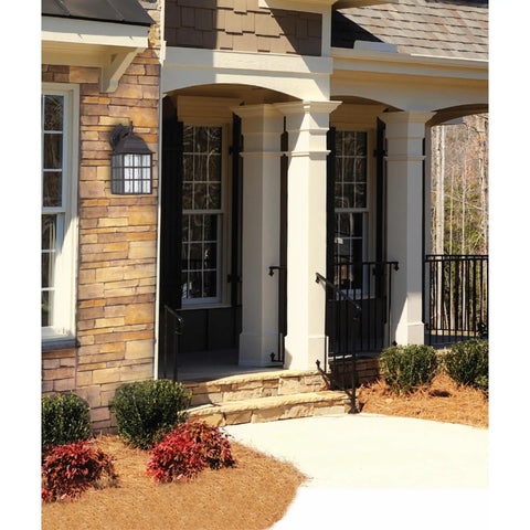 Solid Exterior Wall Lantern Featuring Slick Weathered Patina Cast Aluminum Body Plus Crisp Seeded Glass Panes For Front Porches And Driveways mounted beside front entrance.