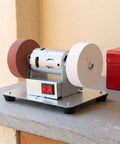 Tough Desktop Belt Sander And Badass Knife Sharpener Featuring Adjustable Grinding Angles compact motorized design with red and white grinding wheels.