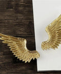Heavy Duty Solid Brass Wardrobe Handles Featuring Slick Matte Gold Angel Wing Design And Badass Cabinet Knobs close-up of gold angel wing handles on wooden surface