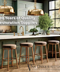 Modern kitchen with gold pendant lamps and wooden counter stools, showcasing high-quality restoration supplies.