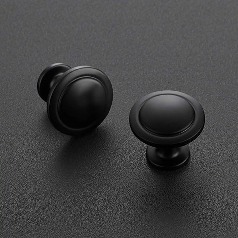 Dang Slick Matte Black Finish Round Cabinet Knobs Zinc Hardware on textured black surface, showcasing two sizes for easy upgrade.