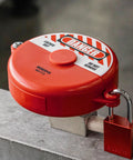 Red ABS Gate Valve Lockout with Padlock for Two Point Five to Five Inch Handles installed, showing lockout and padlock in place.